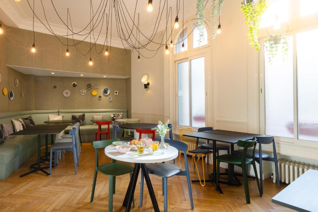 a restaurant with tables and chairs in a room at Hôtel Vendôme in Nice