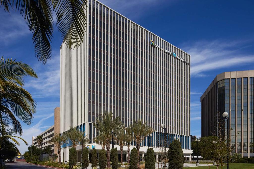 un edificio alto y blanco con palmeras delante en Hyatt Place LAX/Century BLVD en Los Ángeles