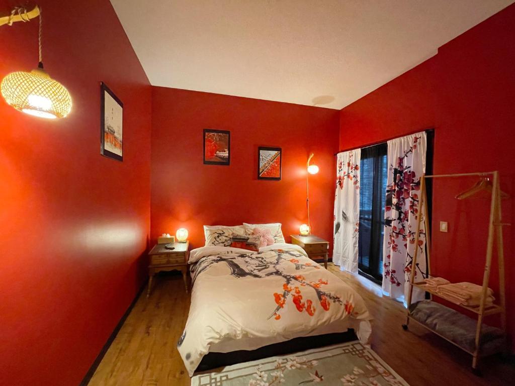 Dormitorio rojo con cama y ventana en Lu Yao Inn OP en Calgary