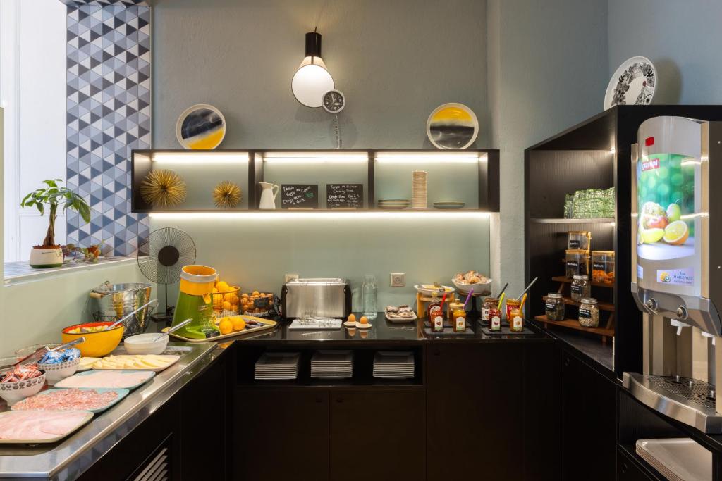 a kitchen with a counter with food and a refrigerator at Hôtel Vendôme in Nice