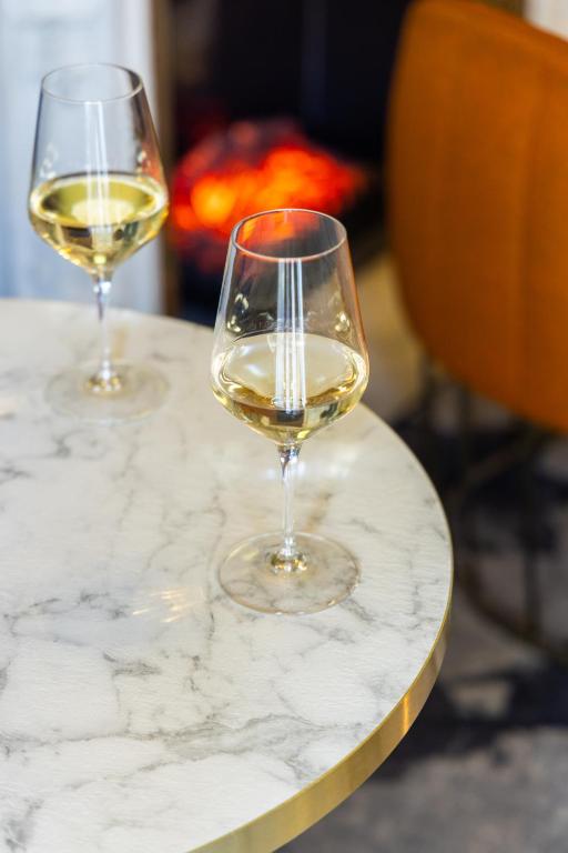 two glasses of white wine sitting on a marble table at Hôtel Vendôme in Nice