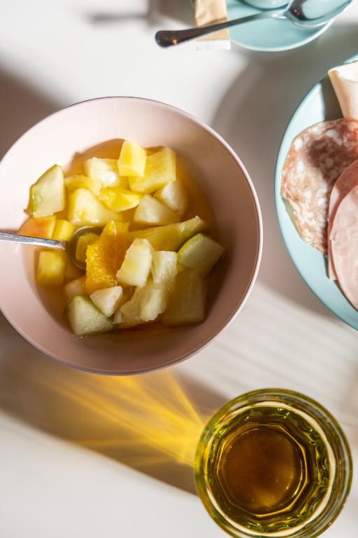 a bowl of fruit and a bowl of honey at Hôtel Vendôme in Nice