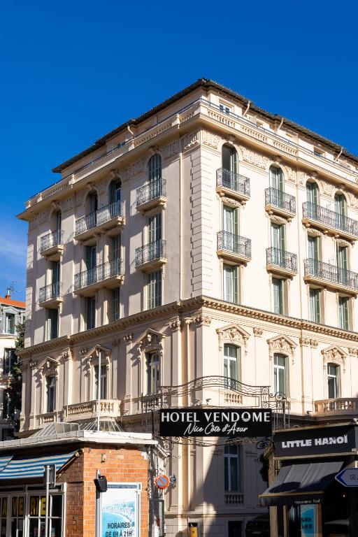 a large building with a hotel in front of it at Hôtel Vendôme in Nice