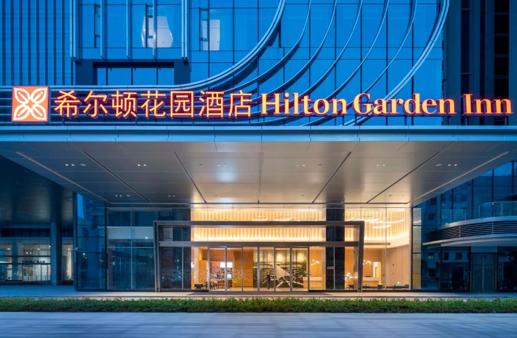 Hilton Garden Inn Shenzhen Airport في شنجن: مبنى فيه لافته مكتوب عليها هيلتون جاردن