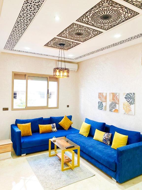 a living room with a blue couch and a table at Appartement calme in Fès