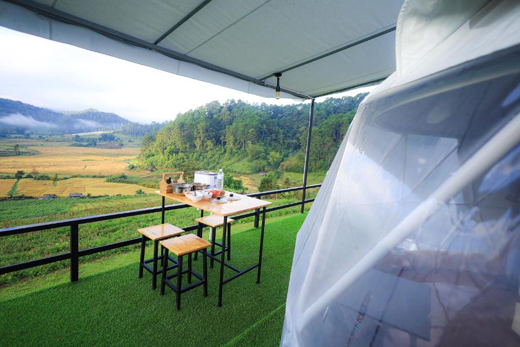 a table and chairs on a balcony with a view at สวนไร่รุ่งอรุณ in Ban Na Pa Paek