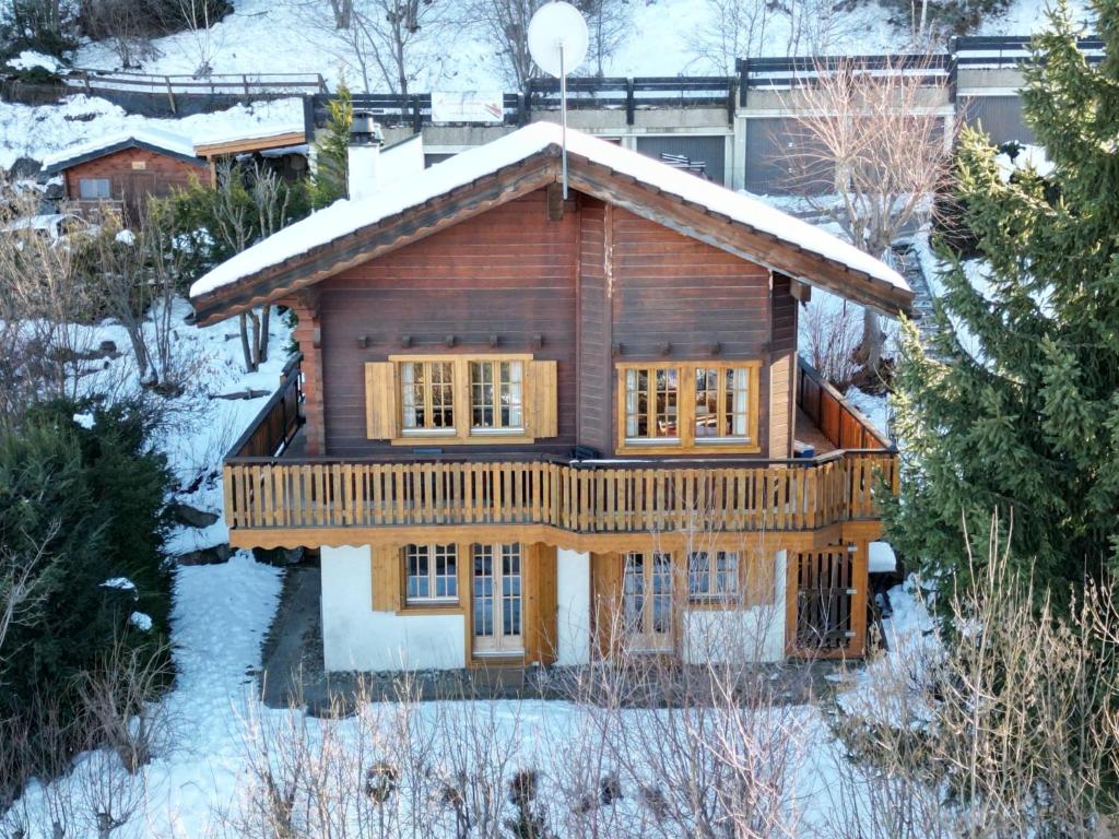 una cabaña de madera en la nieve con nieve en Chalet Les Muguets by Interhome, en Nendaz