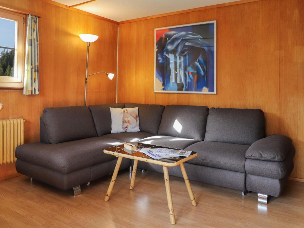 a living room with a couch and a table at Apartment Haus Chumma Apt1 by Interhome in Frauenkirch