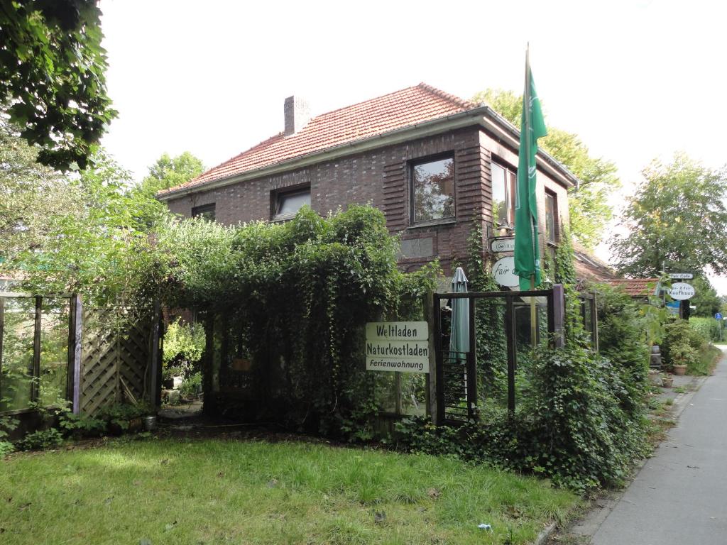 una casa vieja con un cartel delante en Sonnige Etagenwohnung im Waldgebiet, en Schortens