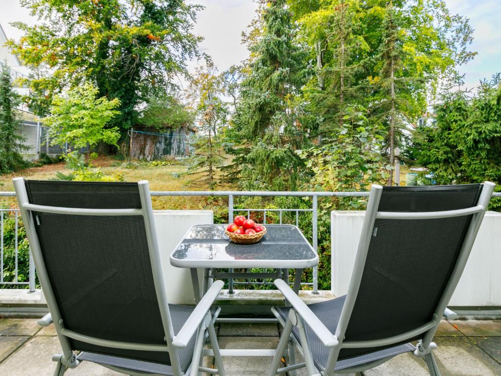 Duas cadeiras e uma mesa num alpendre com uma taça de fruta em Apartment Dünenresidenz-9 by Interhome em Zinnowitz