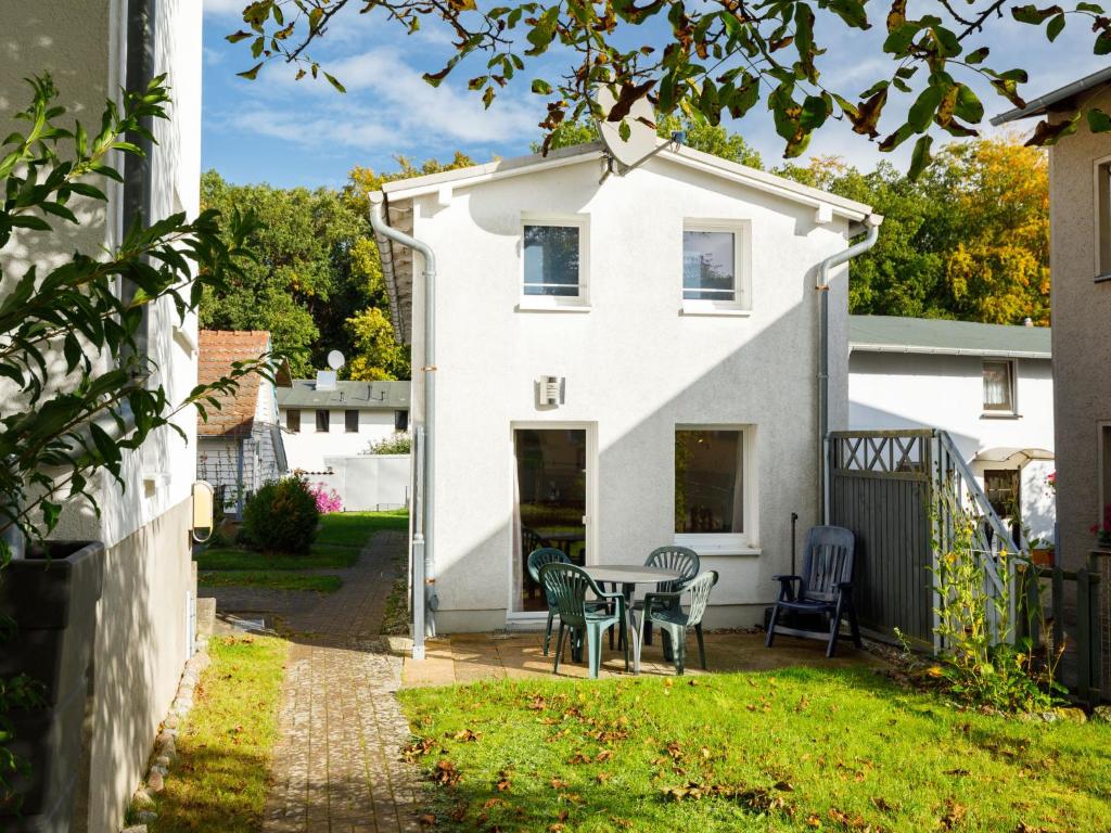 een wit huis met een tafel en stoelen in de tuin bij Holiday Home Delphin by Interhome in Zinnowitz