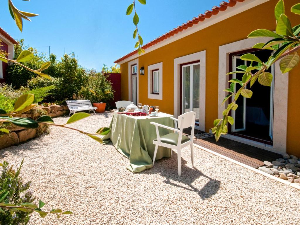 un patio con tavolo e sedie di fronte a una casa di Holiday Home D'Olivia - NZE220 by Interhome a Cela