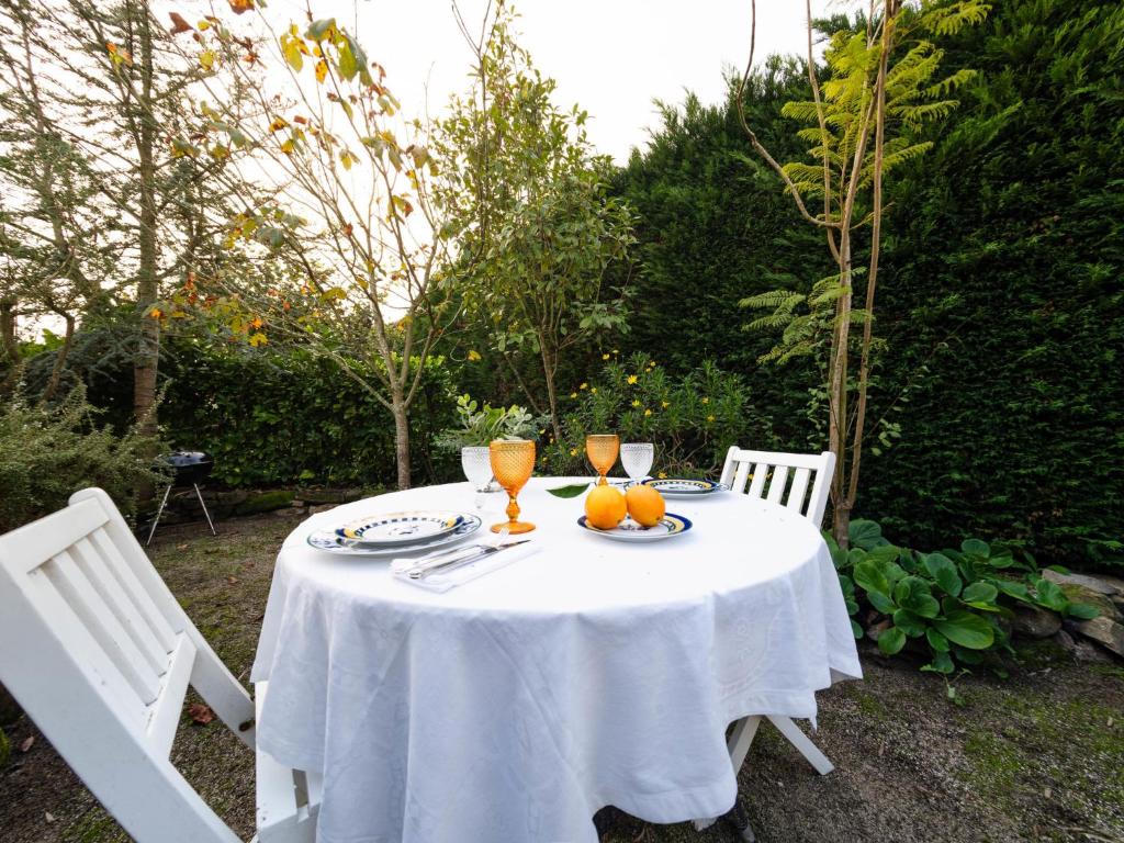 una mesa blanca con vasos y naranjas. en Holiday Home Conceição - NZE221 by Interhome, en Cela