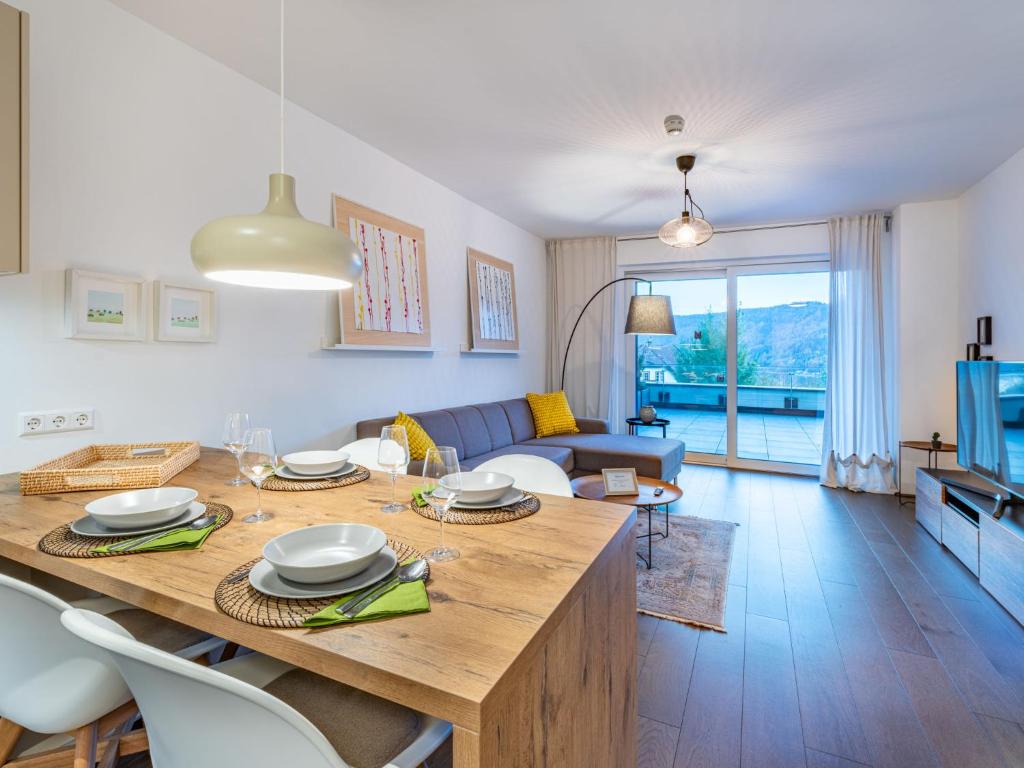een keuken en een woonkamer met een grote houten tafel bij Apartment Seetraum alpe maritima Ski & See Top 3 by Interhome in Annenheim