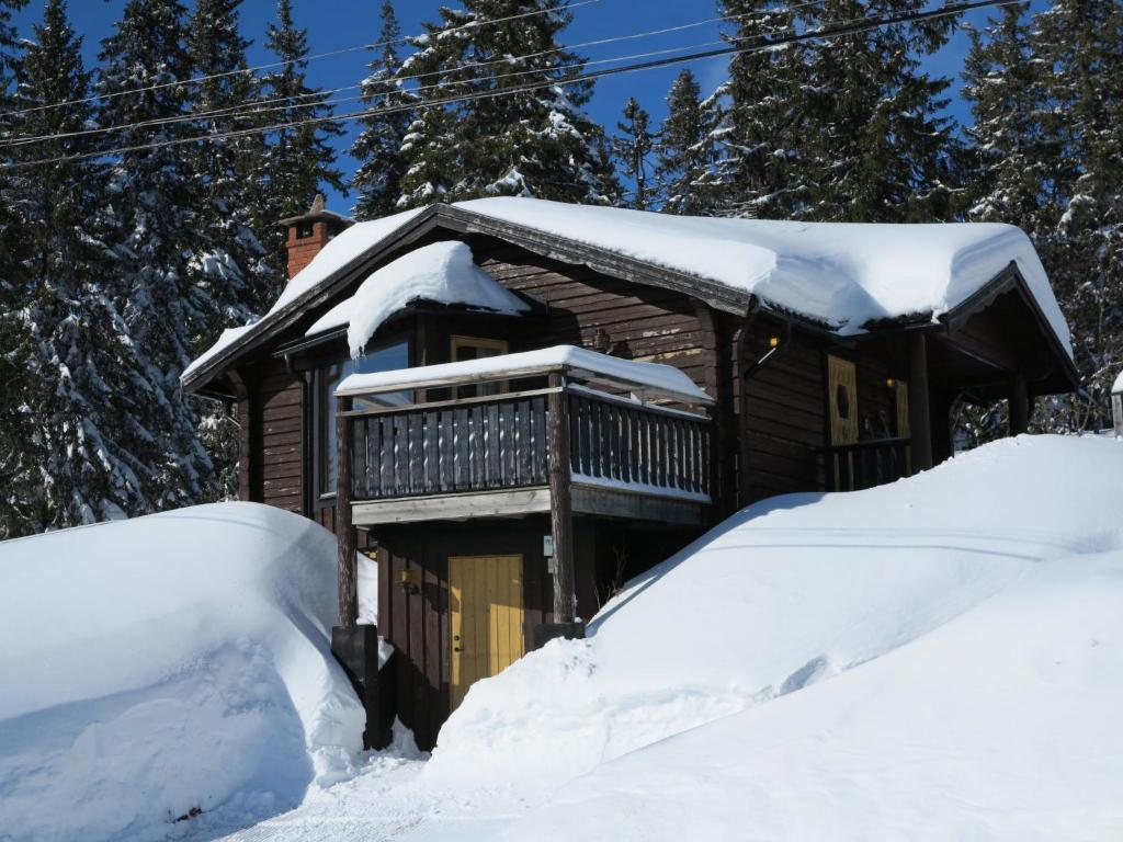 a log cabin in the snow with a pile of snow at Chalet Korpstigen Renen by Interhome in Sälen