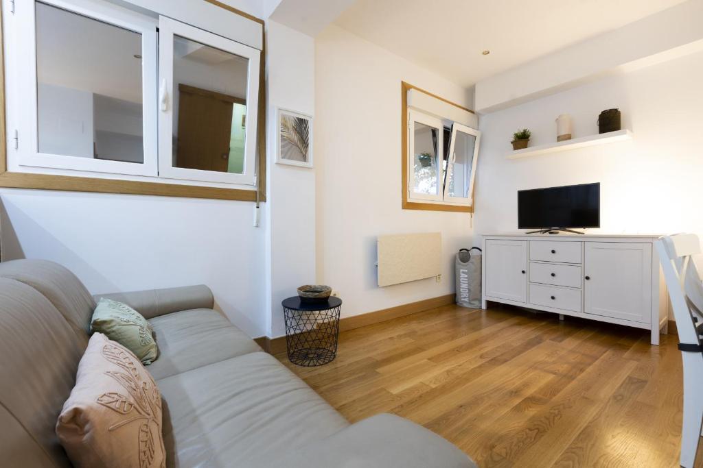 a living room with a couch and a tv at ARROLA by Smiling Rentals in Hondarribia