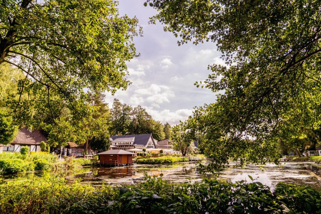 um rio com casas e um barco nele em Forsthaus Seebergen em Lütjensee