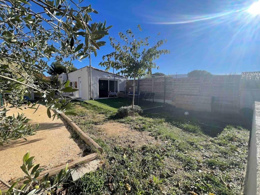 une maison avec un mur et un arbre dans une cour dans l'établissement Maison plain pied au calme, à Cuges-les-Pins