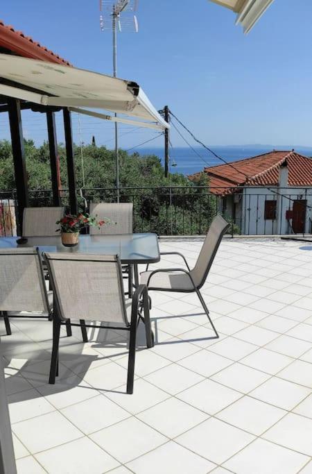a patio with a table and chairs and an umbrella at Villa Magda in Syvota