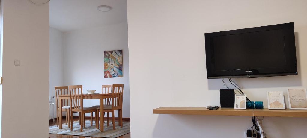 een woonkamer met een tv en een tafel en stoelen bij Luka 1718 Apartments in Belgrado