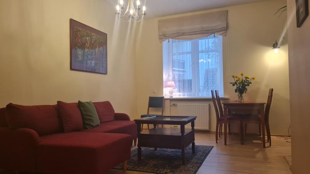 a living room with a red couch and a table at Rehouse, Antokolskio 13 in Vilnius