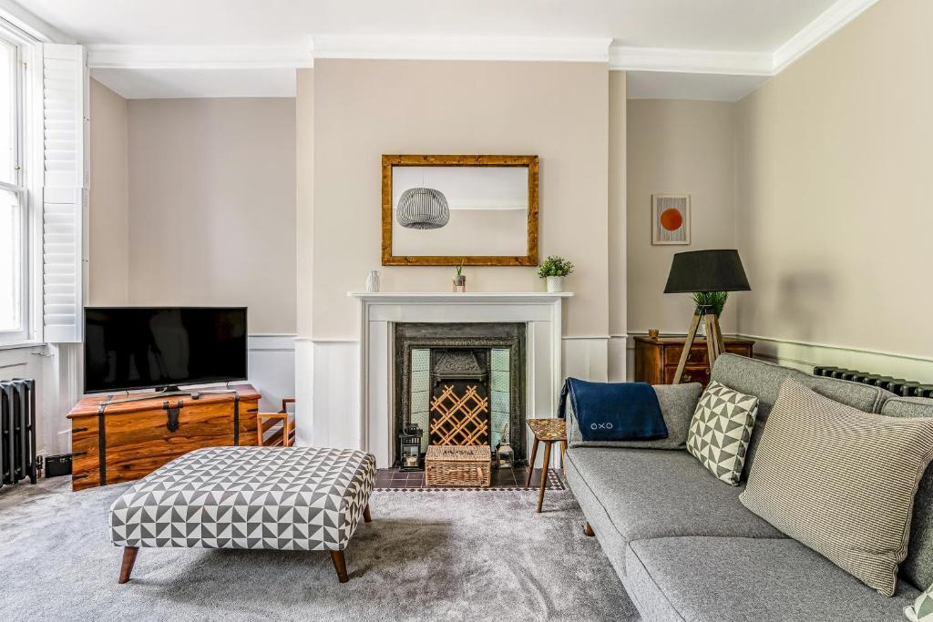 a living room with a couch and a fireplace at Pass the Keys Luxury Converted Victorian Flat in Leafy Highbury in London
