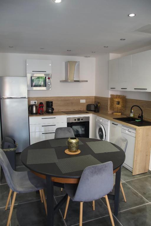 une cuisine avec une table et des chaises dans une cuisine dans l'établissement Appt 4/6 pers à 400 mètres de la plage, à Dunkerque