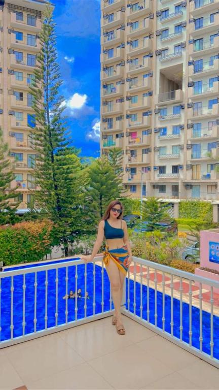 una mujer parada en un balcón frente a un edificio en Condo in Davao city 2 bedroom Camella north point, en Davao City