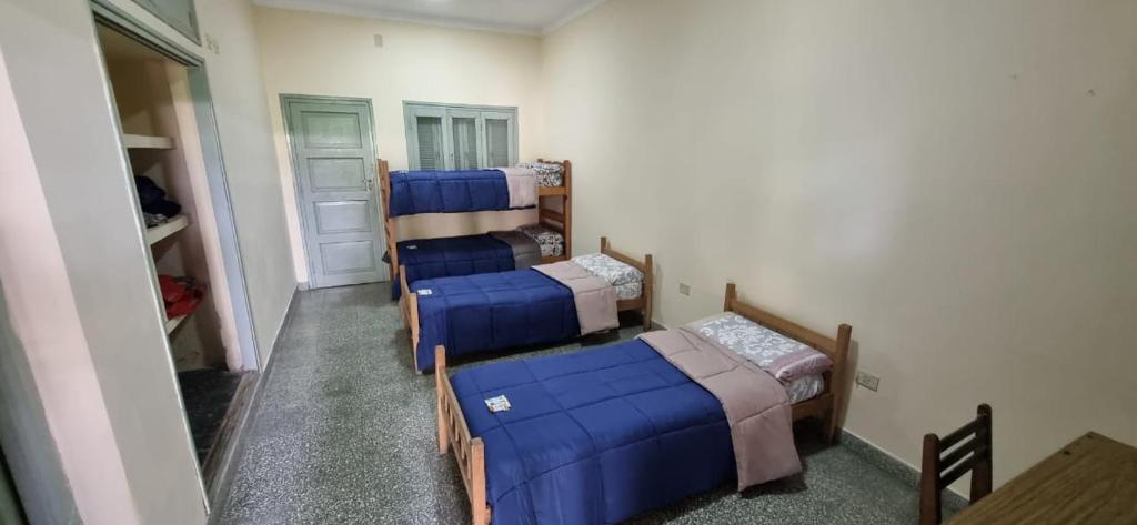 a group of four beds in a room at Alojamiento en pleno centro de Corrientes in Corrientes