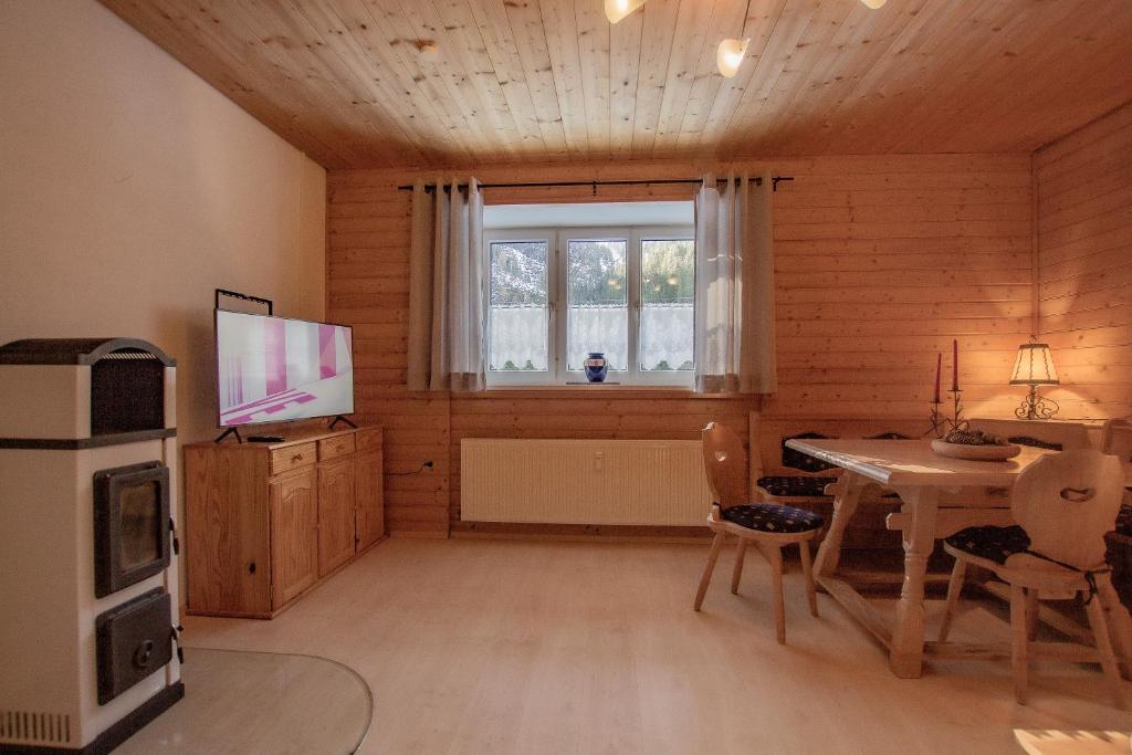 uma sala de estar com uma mesa e uma televisão em Apartment Paletti 23 em Enzingerboden