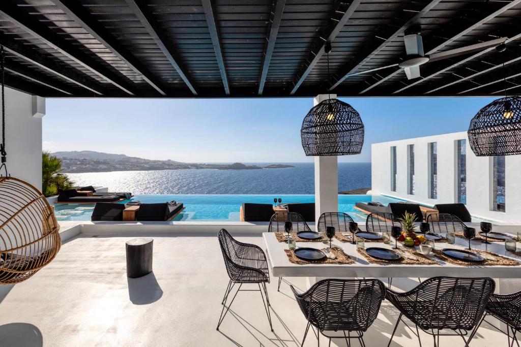 a dining room with a view of the ocean at Psarou Black Villas in Mýkonos City