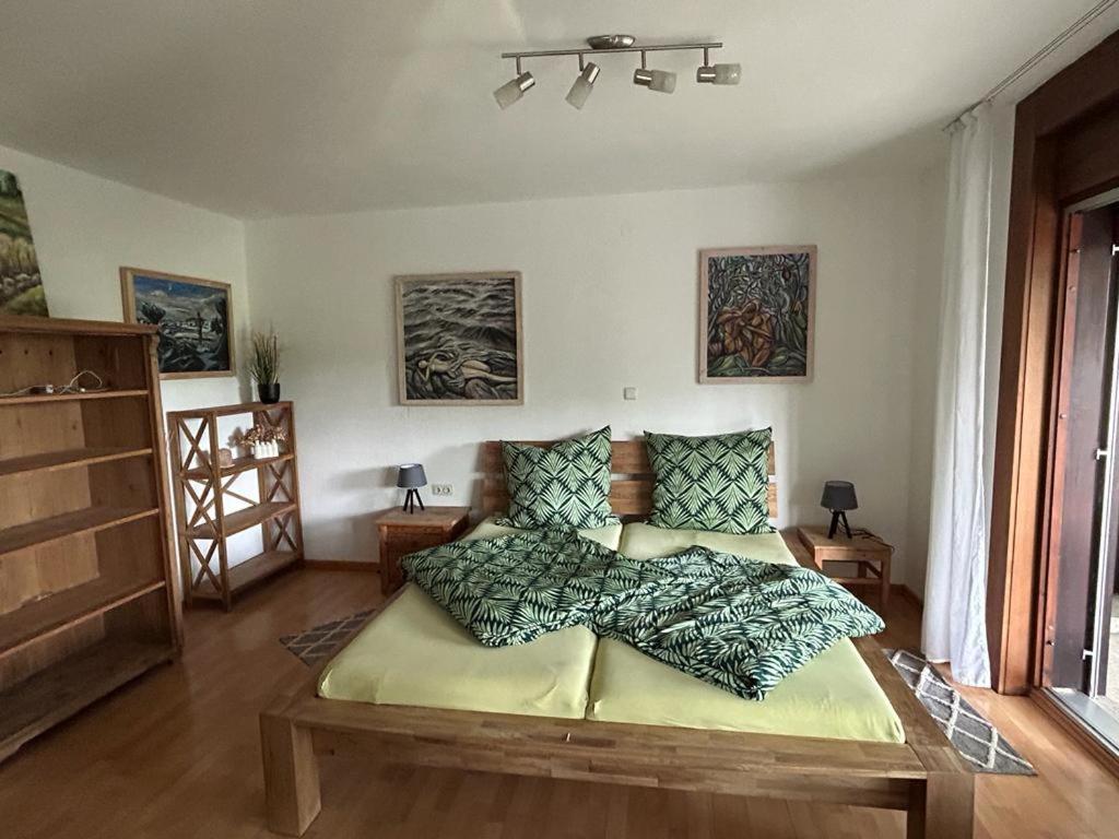 a bedroom with a large bed with a wooden table at Ferienwohnung An der Loipe in Lichtenstein