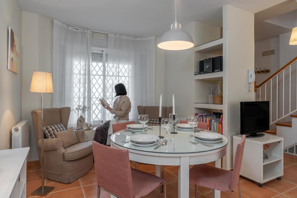 a woman in a living room with a table and chairs at tuGuest Armilla House in Armilla