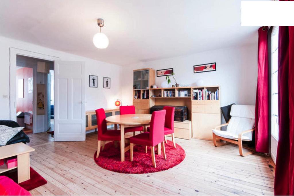 un salon avec une table et des chaises rouges dans l'établissement Duplex Lille-Centre, à Lille