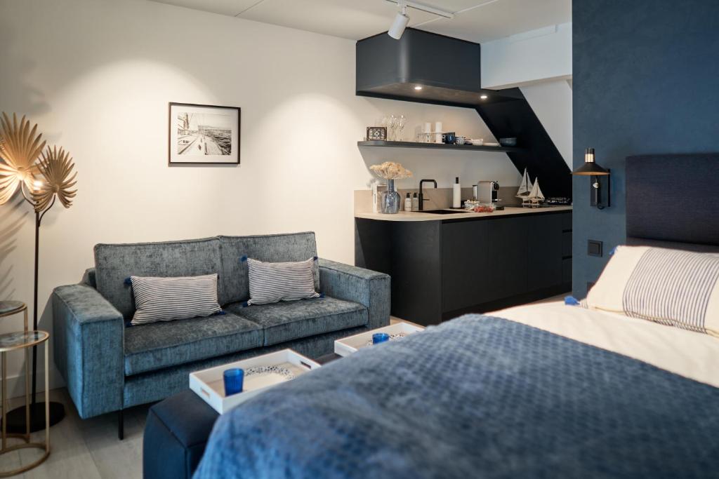 a living room with a bed and a couch at Captains Boathouse Studio in Harderwijk