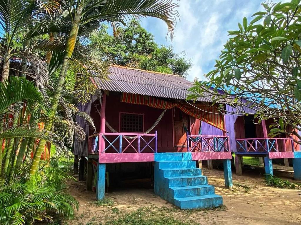 ein Haus mit einem rosa und blauen Dach und einer Treppe in der Unterkunft Fat Rabbit Beach Resort in Kep