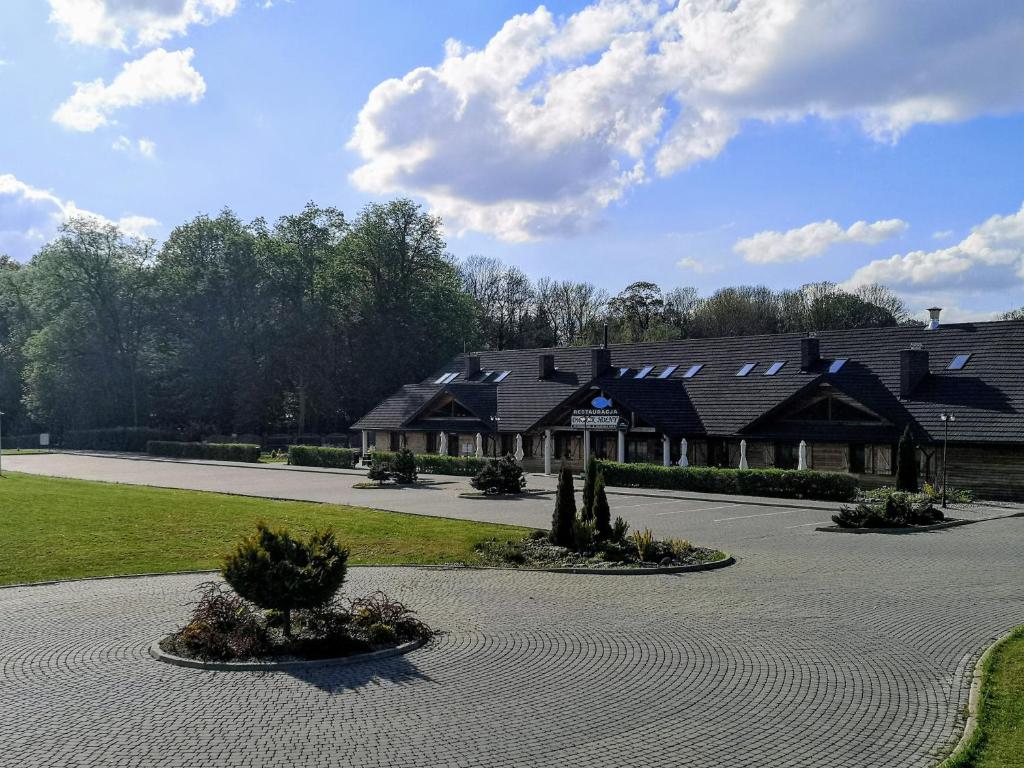 a large house with a driveway in front of it at Dworek Hołny in Hołny Mejera