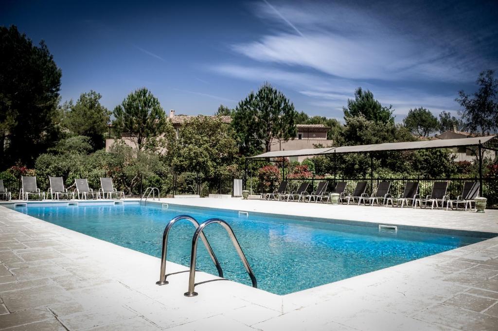einen großen Pool mit Stühlen in der Unterkunft Les Appartements et Maisons du Domaine de Saint Endréol Golf & Spa Resort in La Motte