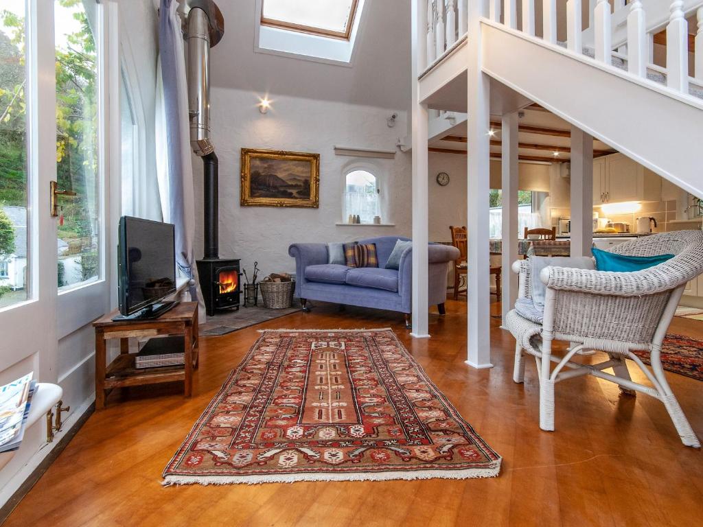 ein Wohnzimmer mit einem blauen Sofa und einem Kamin in der Unterkunft Wisteria Lodge - Qc1677 in Cilgwm