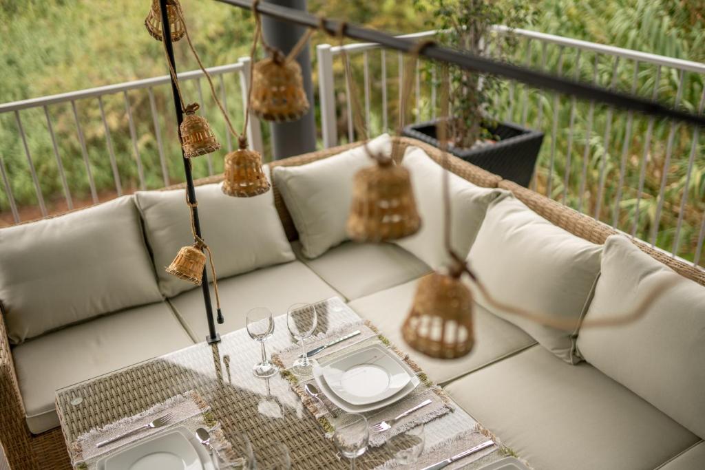 un sofá blanco en un balcón con mesa en Villa 65 - City Edge Retreat en Funchal