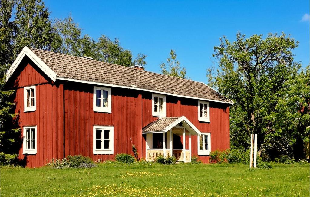 a red barn with white windows on a green field at Lovely Home In Lingbo With Wifi in Lingbo