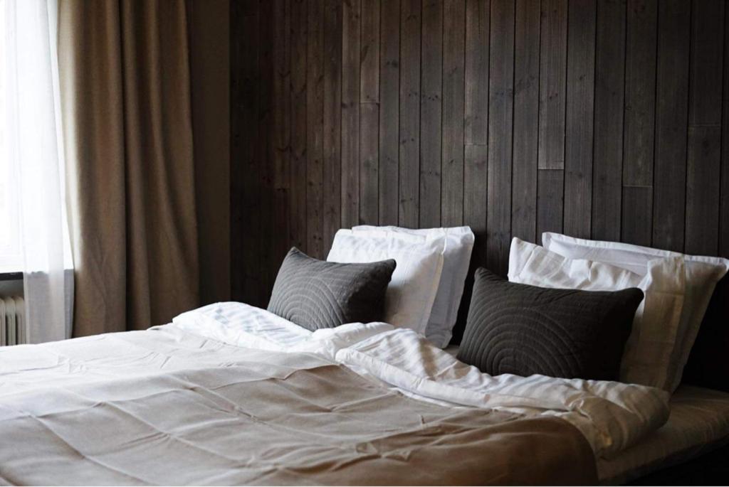 1 cama grande con sábanas y almohadas blancas en Steel Hotel en Smedjebacken