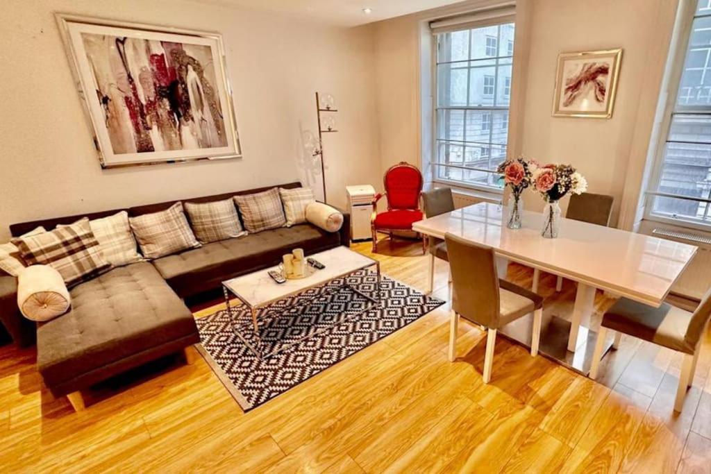 a living room with a couch and a table at Haymarket 2: Large Central Apt! in London