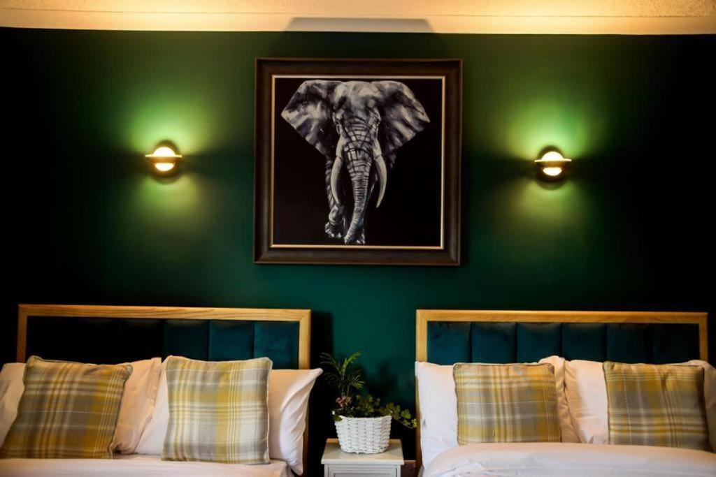 a bedroom with two beds and a picture of an elephant at Lomond Park Hotel in Balloch