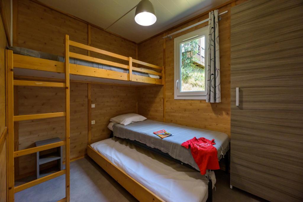 a bedroom with two bunk beds and a window at Camping U Pirellu in Porto-Vecchio