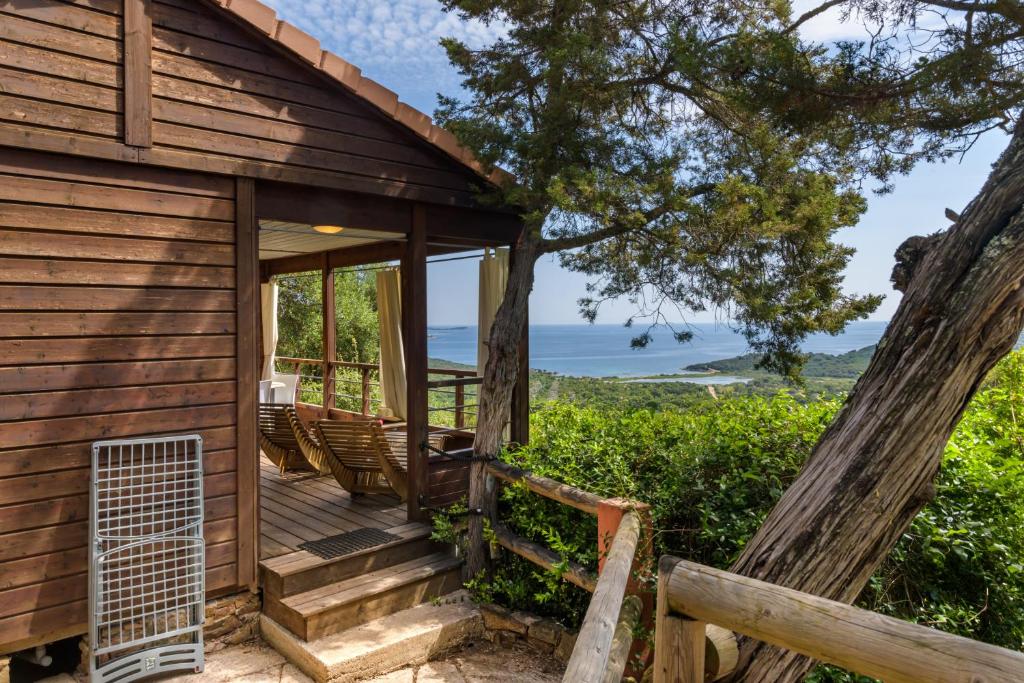 a cabin with a deck with a view of the ocean at Camping U Pirellu in Porto-Vecchio