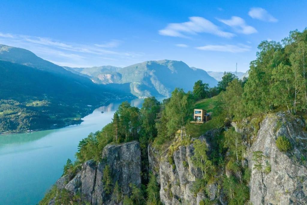 a house on the side of a mountain overlooking a lake at Sørheim FjordPanorama in Skjolden