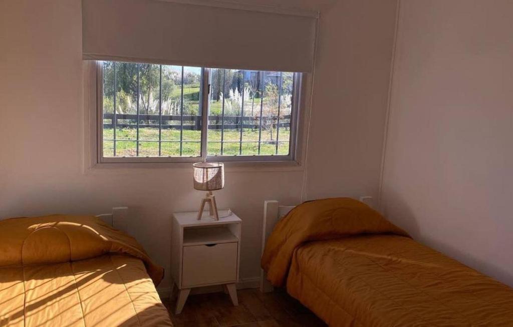 1 dormitorio con 2 camas y ventana en Casa Quinta Con Piscina En Barrio Náutico en Villa Paranacito