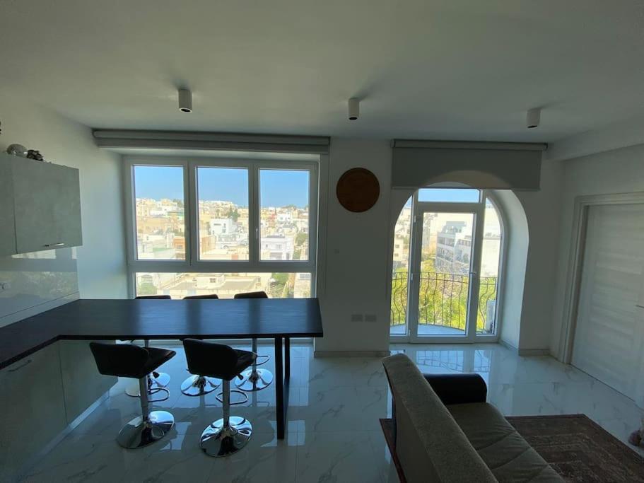 a living room with a table and some chairs at Lovely 1-bedroom in St Julians in St Julian's