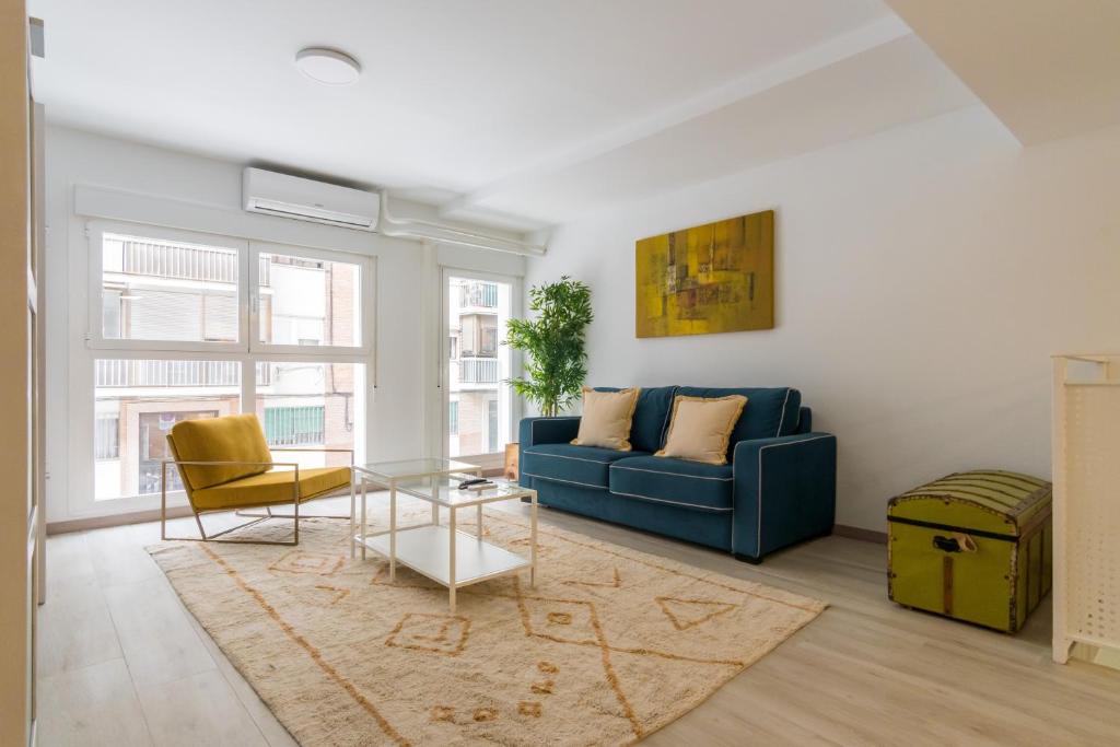 sala de estar con sofá azul y mesa en Bright new and wide- 1Bd 1Bth- Delicias, en Madrid